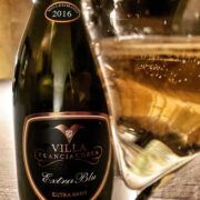 bottiglia e calice di champagne villa franciacorta extra brut selezione 2016