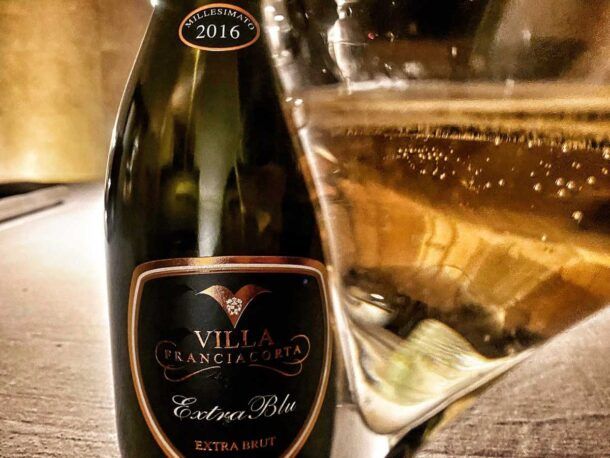 bottiglia e calice di champagne villa franciacorta extra brut selezione 2016